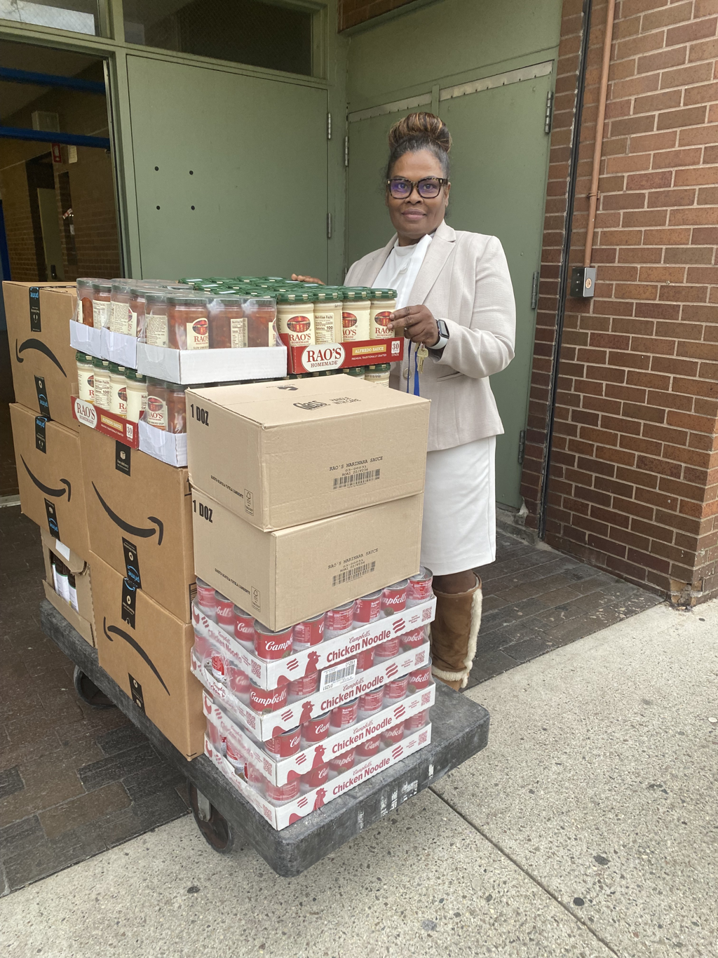 Picture of our Principal, Dr. King, taking delivery of boxes of food items for our new community pantry!